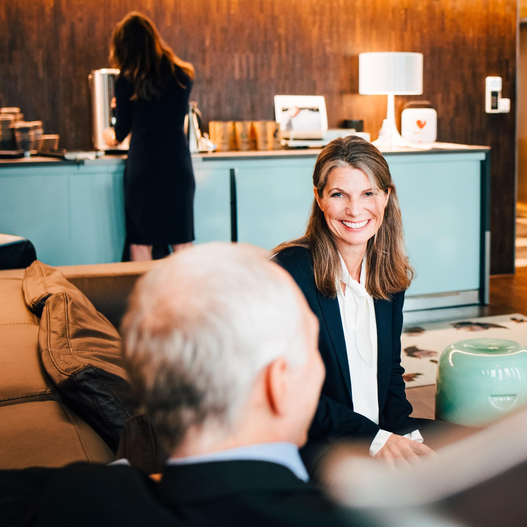 Glad kvinna på möte i konferenslokal.