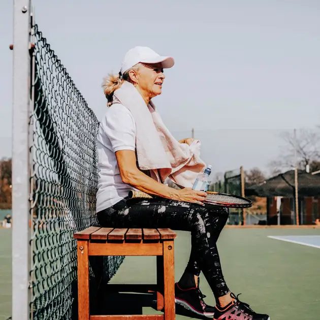 Kvinna spelar tennis.
