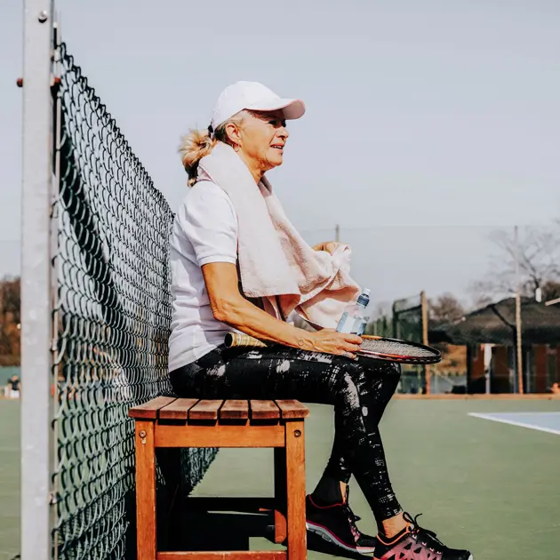 Kvinna spelar tennis.