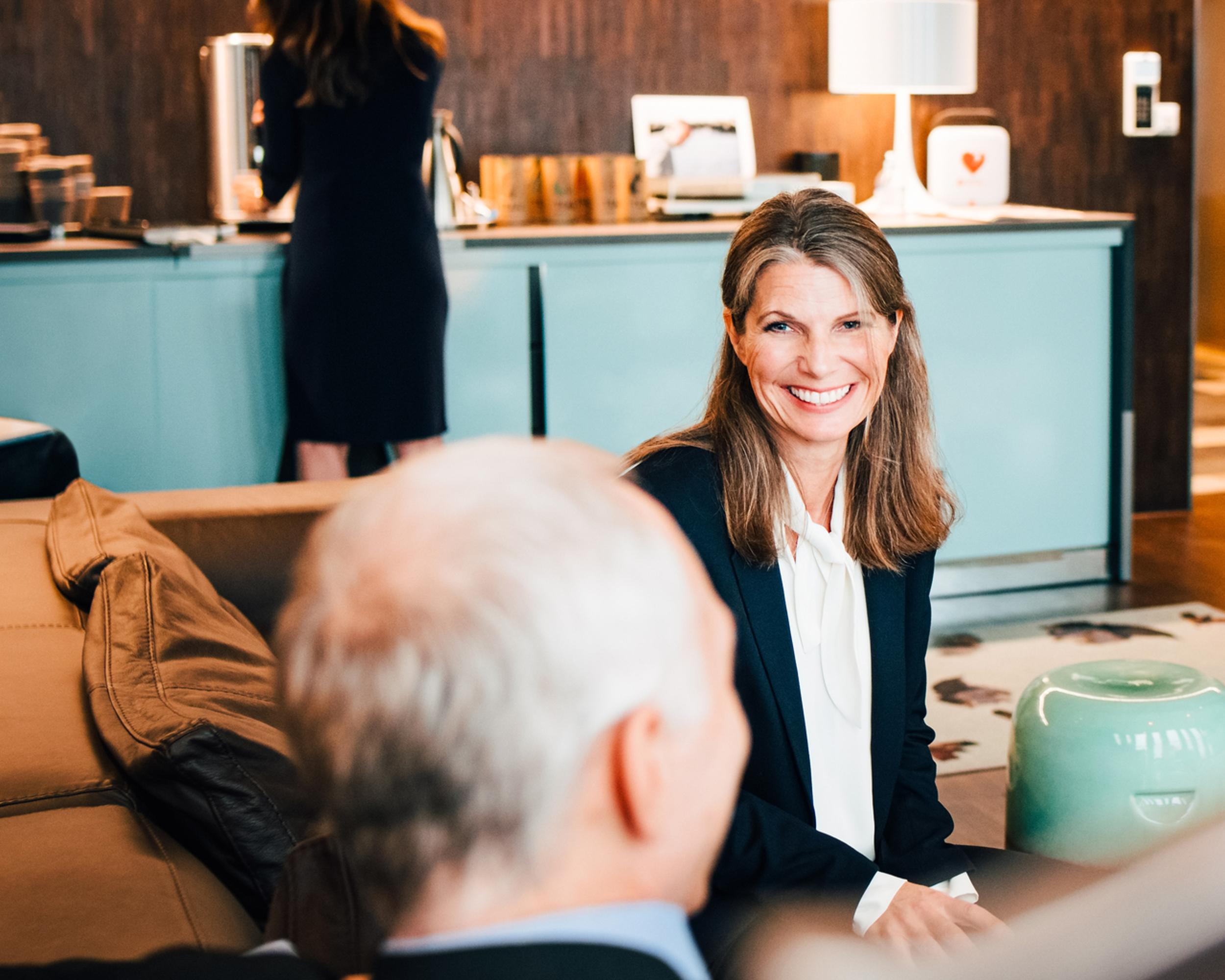 Glad kvinna på möte i konferenslokal.