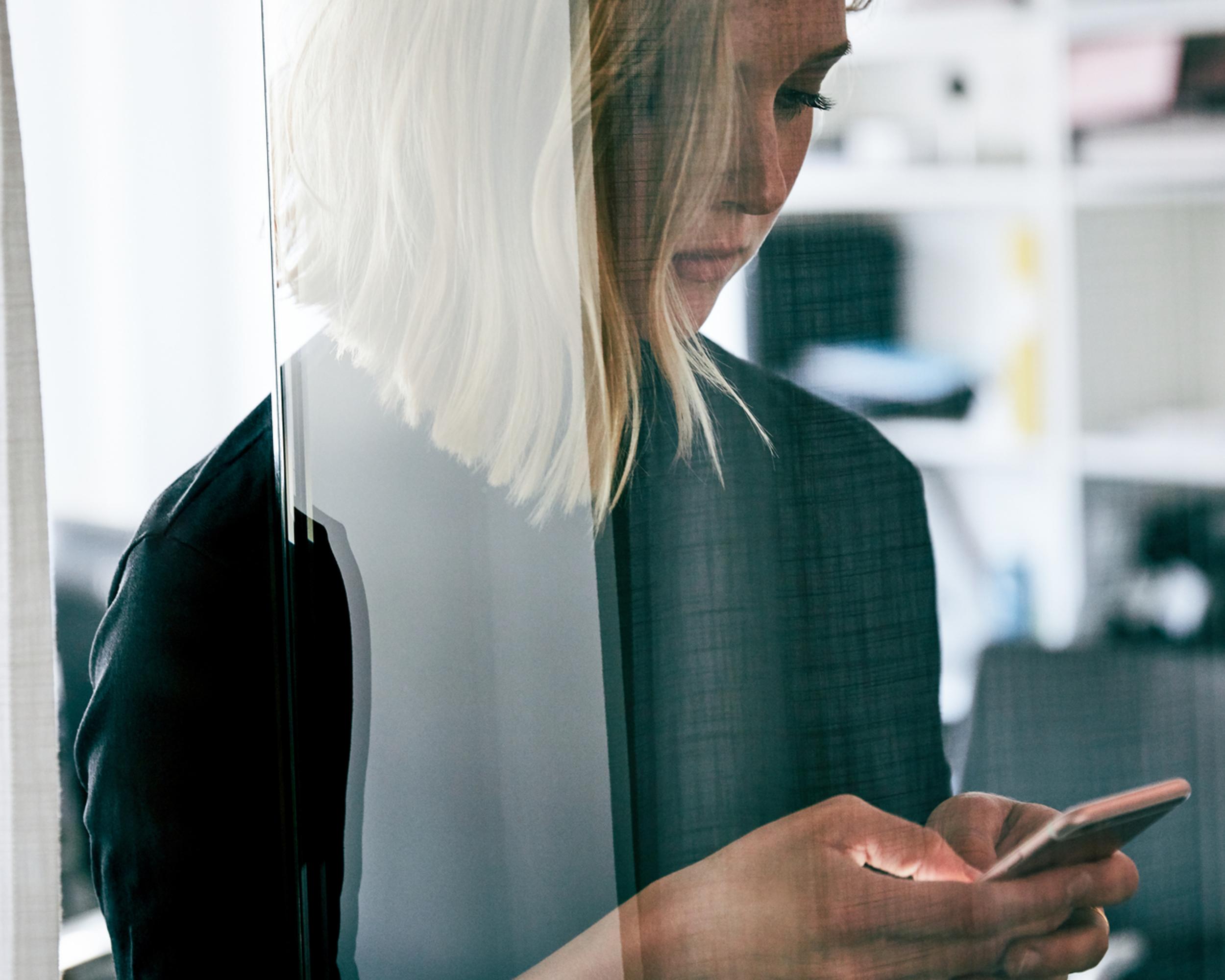 Kvinna med mobil i handen