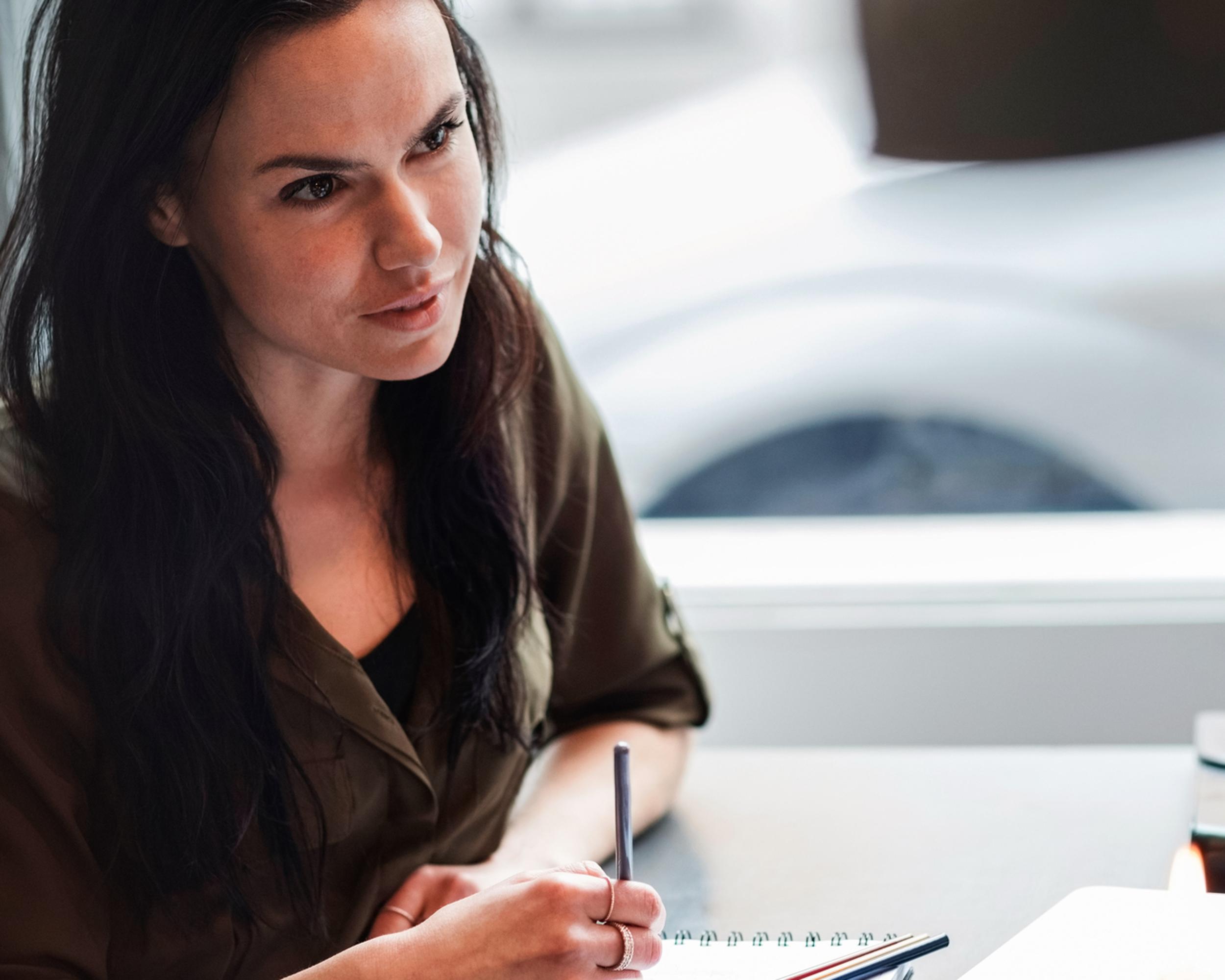 Kvinna med papper och penna.