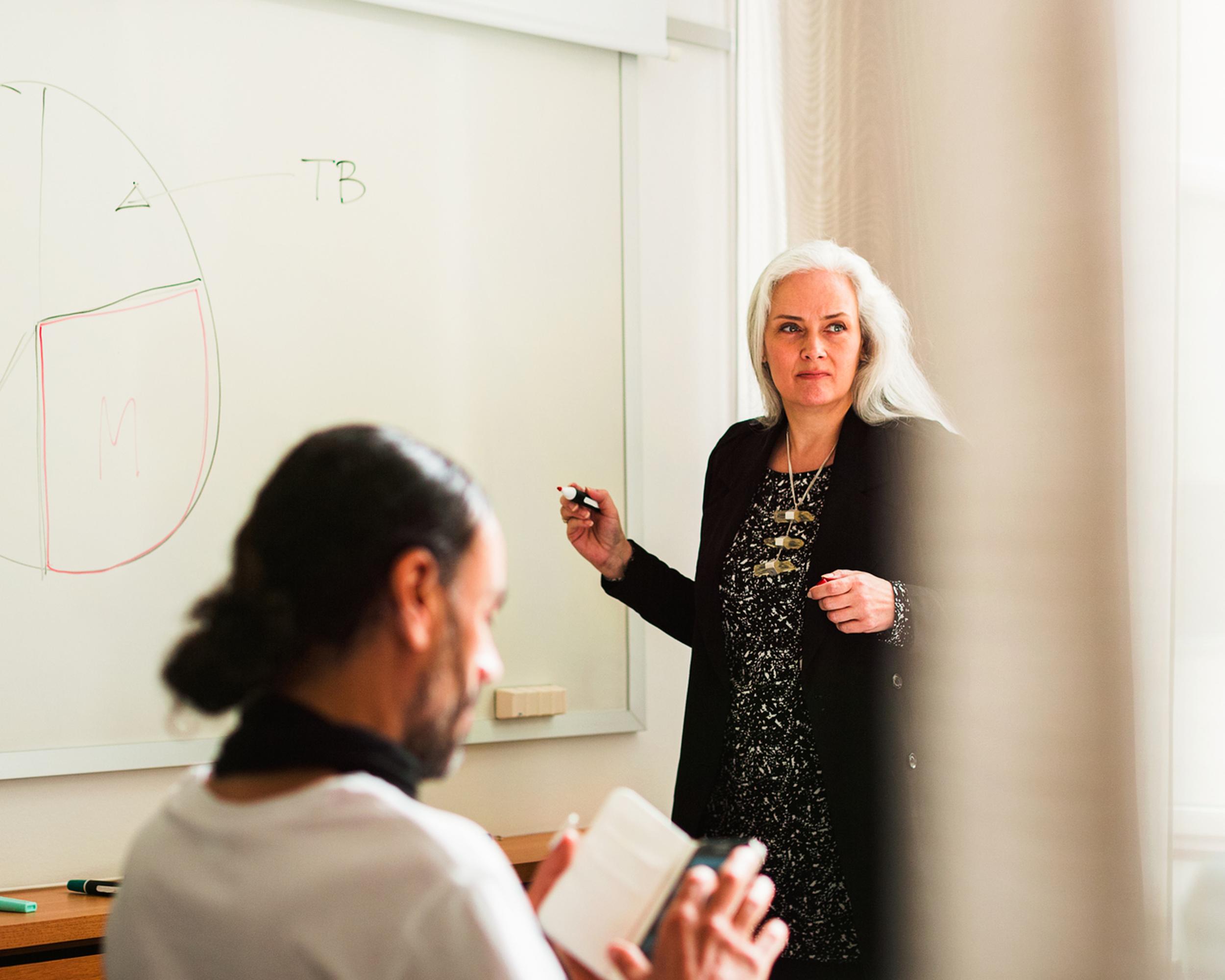 Kvinna vid whiteboard på möte