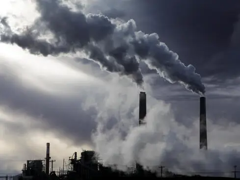 Rök från fabriksskorstenar mot en mörk himmel, vilket illustrerar miljöförorening och industriell påverkan på luftkvaliteten