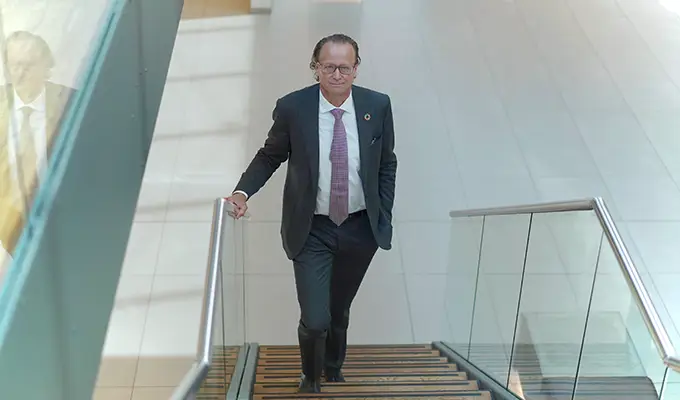 Man i kostym går uppför trappa i modernt kontorslandskap