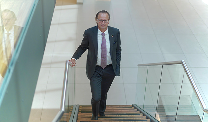 Man i kostym går uppför trappa i modernt kontorslandskap