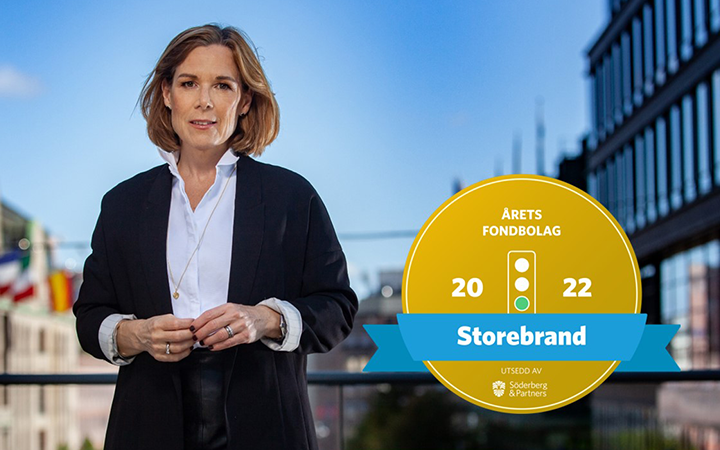 Kvinna framför en modern byggnad med en utmärkelse för Storebrand som "Årets Fondbolag 2022" från Söderberg & Partners