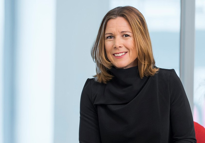 Åsa Wallenberg i svart klänning ler mot kameran i ett modernt kontor