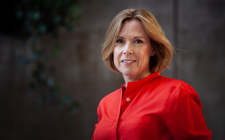 Åsa Wallenbergi röd skjorta mot suddig bakgrund