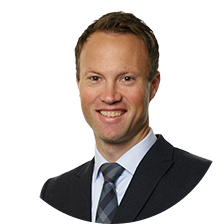 Businessman i en kostym med slips, leende, mot vit bakgrund
