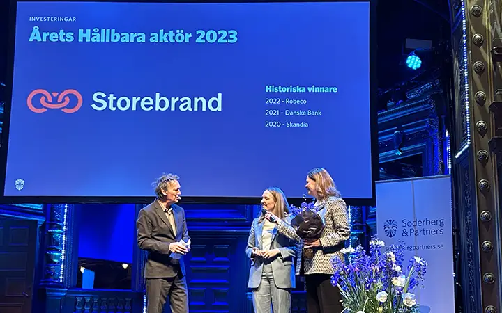 Storebrand mottar utmärkelsen "Årets Hållbara Aktör 2023" vid en ceremoni organiserad av Söderberg & Partners, med presentation på en scen omgiven av blommor