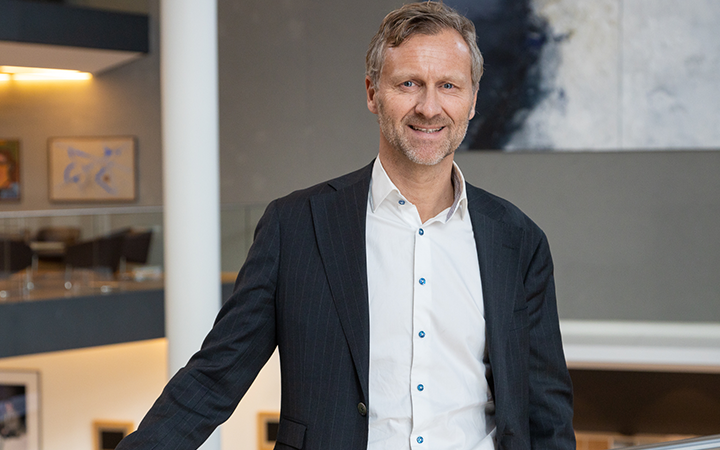 Björn Nass i kostym står i ett modernt kontorsutrymme