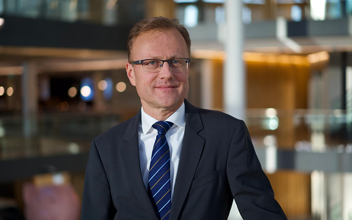 Man i kostym och slips står i en modern kontorsmiljö