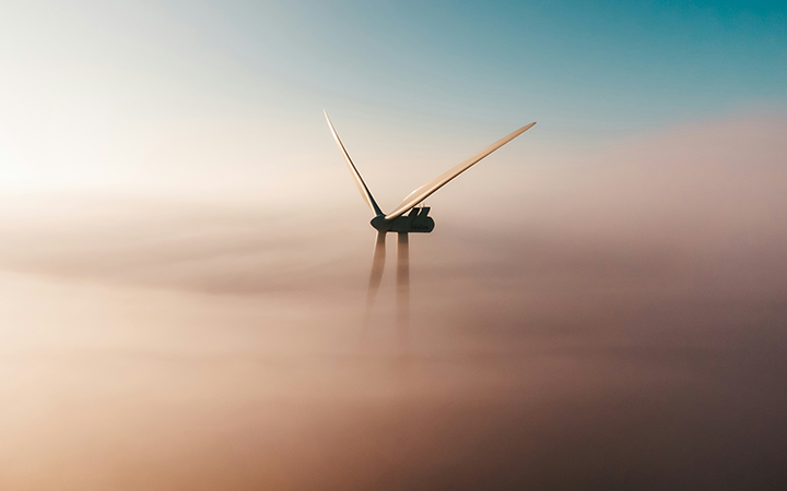 Vindkraftverk ovan molnen i en klar himmel