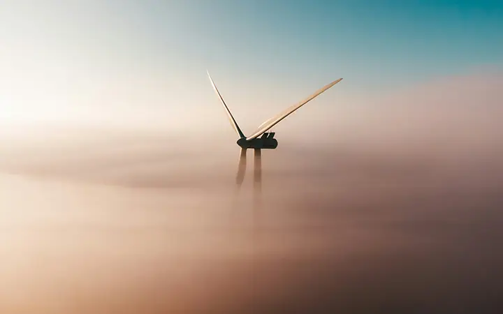 Vindkraftverk ovan molnen i en klar himmel