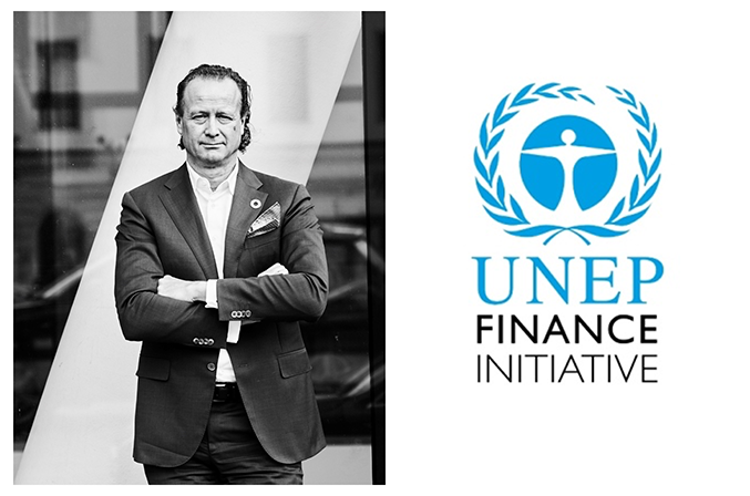 Jan Erik Saugestad i kostym står med armarna i kors framför en glasvägg, bredvid logotypen för UNEP Finance Initiative
