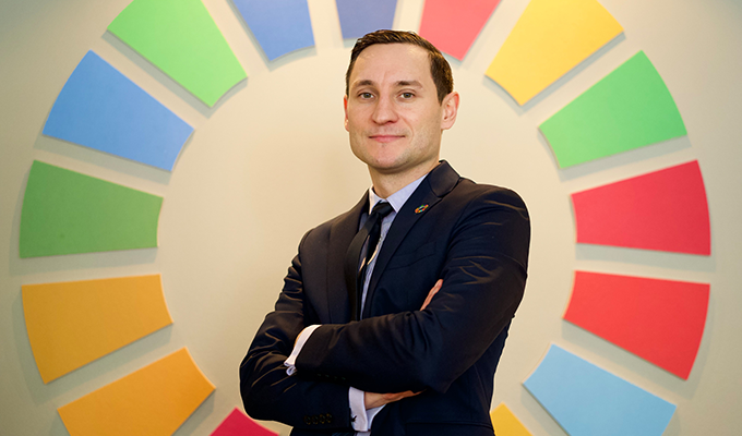 Affärsman i kostym framför färgglad cirkel med segment, symboliserande mångfald och samarbete