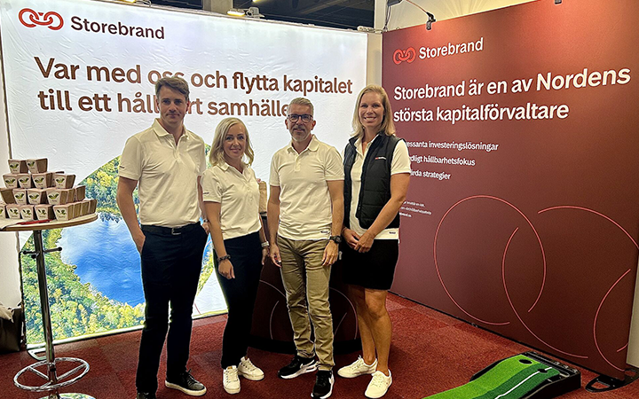Fyra personer står framför Storebrands monter med banderoller om hållbar kapitalförvaltning på en mässa