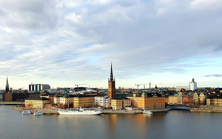 Panoramautsikt över Gamla stan i Stockholm med historiska byggnader och Riddarholmskyrkan, omgiven av vatten och himmel