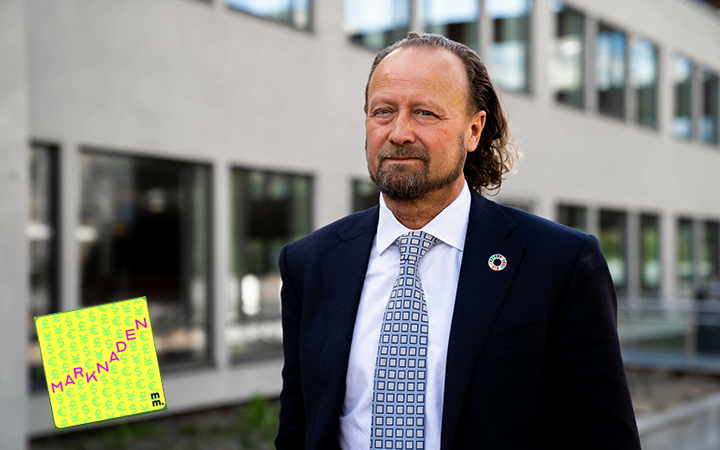 Man i kostym utanför en kontorsbyggnad, bär en slips med rutigt mönster och en pin på kavajslaget. I hörnet syns en bok med titeln "Marknaden"