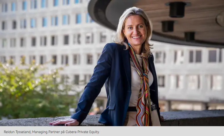 En kvinna i affärskläder med en färgglad scarf står utomhus vid en modern byggnad