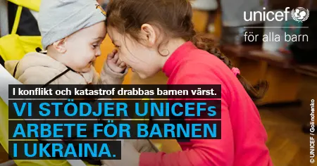 Barn i Ukraina ler mot varandra med en UNICEF-skylt som uppmanar till stöd för deras arbete i landet