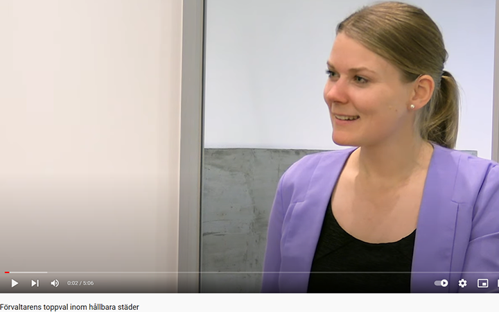 Sunniva Bratt Slette i lila kavaj ler inomhus, med fokus på hållbara städer