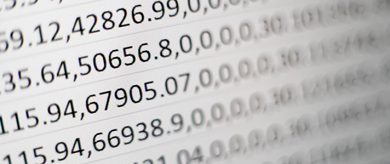 Närbild av en datorskärm med rader av numeriska data och tabeller, idealisk för analys och beräkningar