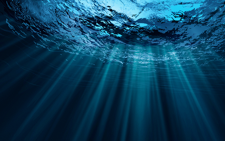 Undervattensvy med solstrålar genom blått vatten