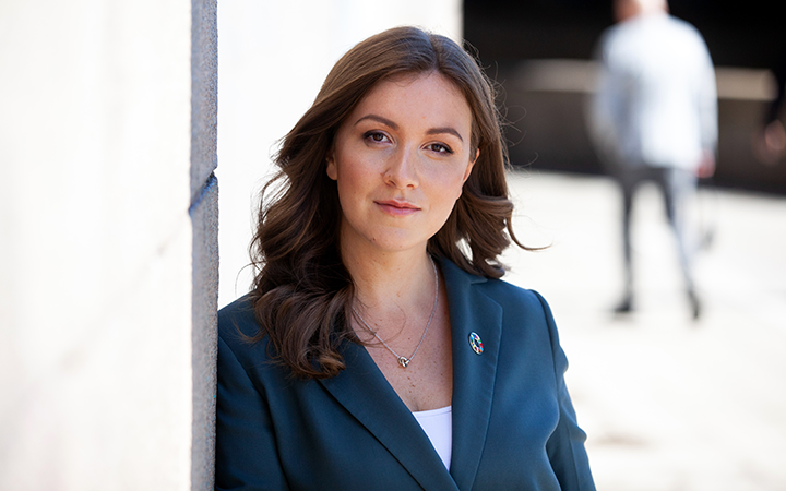 Victoria Liden i affärskostym lutar mot en vägg utomhus