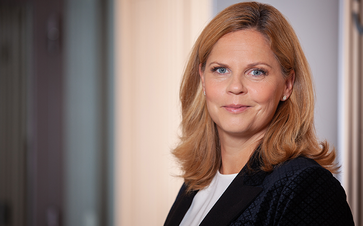 Mia Nyberg i affärskläder med ljusbrunt hår, ser professionell och självsäker ut på kontor