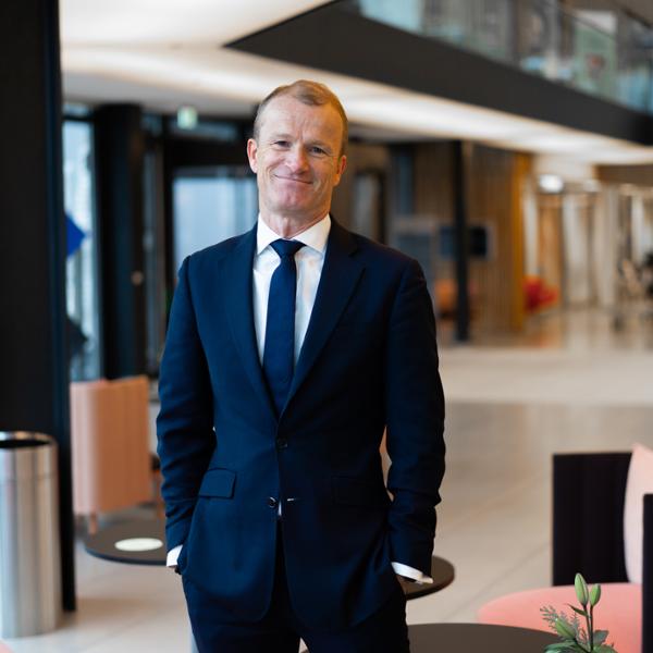 Man i kostym som står i ett modernt kontorslandskap